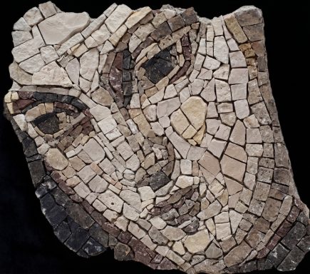 Antikes Mosaik-Gesichtsbruchstück Relief-Mosaik eines Gesichts in monochromen Natursteintönen mit unregelmäßigen Rändern.