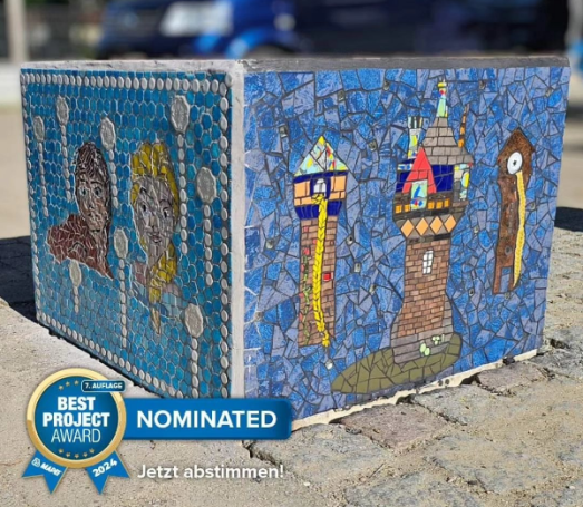 Märchenhafter Mosaik-Würfel Farbenfroher Mosaik-Sitzwürfel mit Märchenmotiven wie einem Rapunzelturm, gestaltet von Caroline Jung.