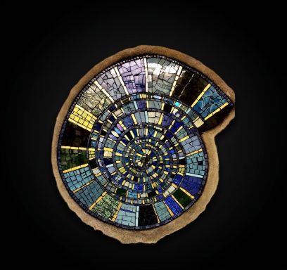 Spiralförmiges Wandmosaik (Ammonit) Spiralförmiges Mosaik, das an einen Ammoniten erinnert, in Blautönen und Gold auf schwarzem Grund.