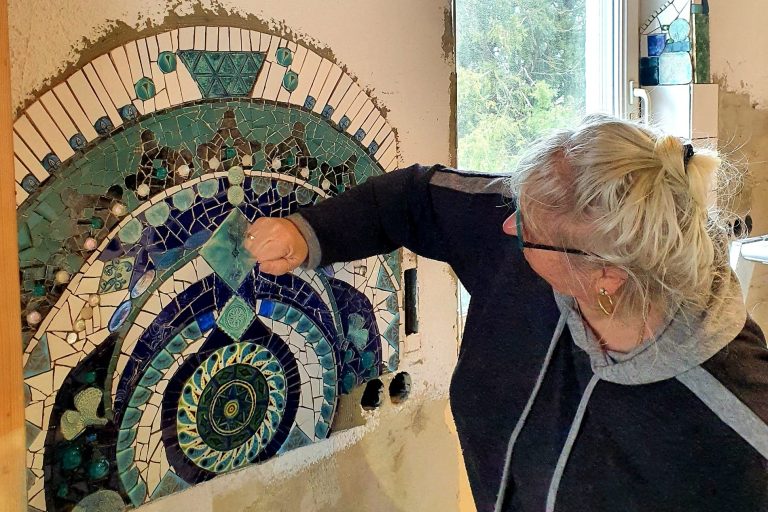 Fachgerechte Installation eines handgefertigten Wandmosaiks durch die Künstlerin Caroline Jung direkt beim Kunden vor Ort.