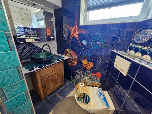 Mosaik-Seestern-Wand Großes, strukturiertes blaues Mosaik-Wandbild mit einem prominenten orangefarbenen Seestern-Design